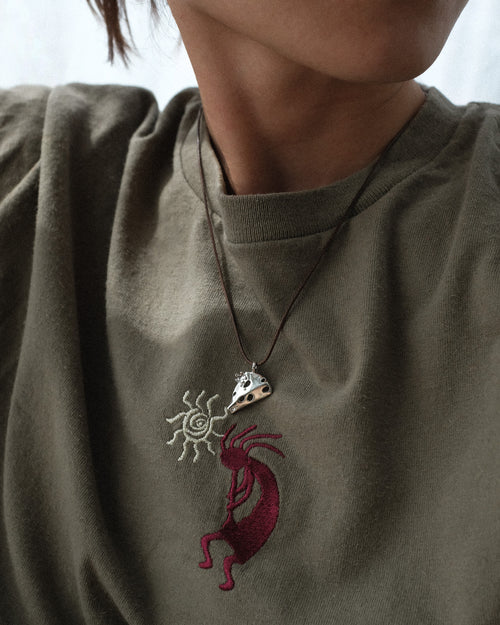 Kiki's Sardine pendant necklace worn with an olive green sweatshirt